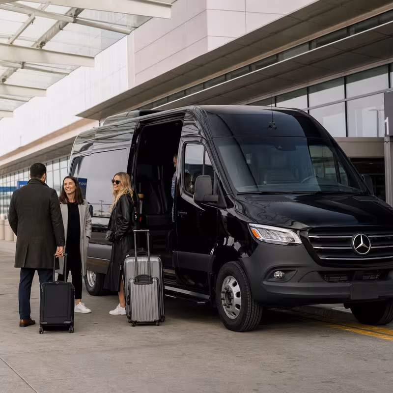 Group boarding a white charter bus for Airport Transportation transportation in Indianapolis