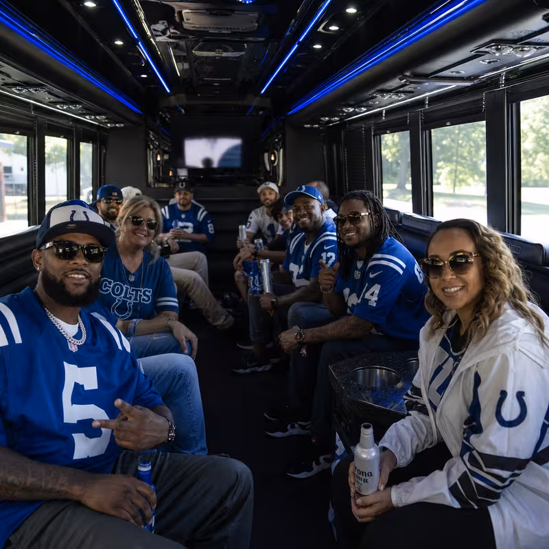 Group boarding a white charter bus for Sporting Event Transportation transportation in Indianapolis